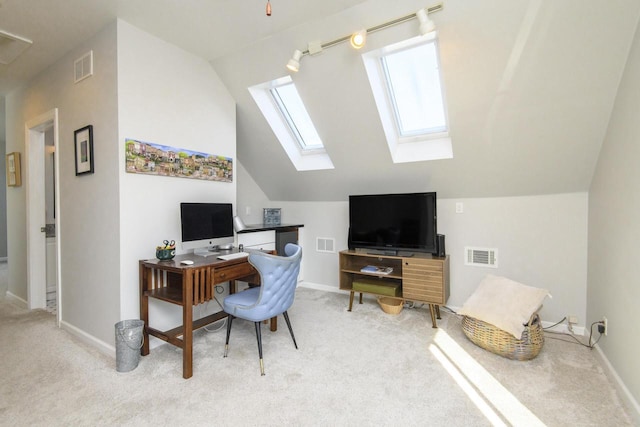 carpeted home office featuring visible vents, vaulted ceiling with skylight, and baseboards