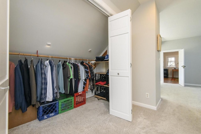 walk in closet with vaulted ceiling and carpet floors