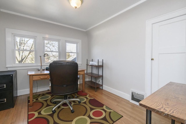 office featuring baseboards, wood finished floors, visible vents, and ornamental molding