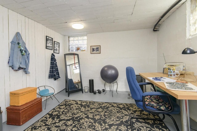 office space featuring concrete flooring and concrete block wall