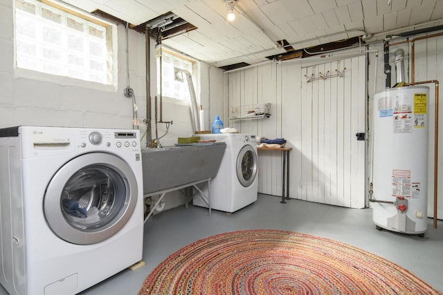 laundry area featuring laundry area, washing machine and dryer, water heater, and a sink