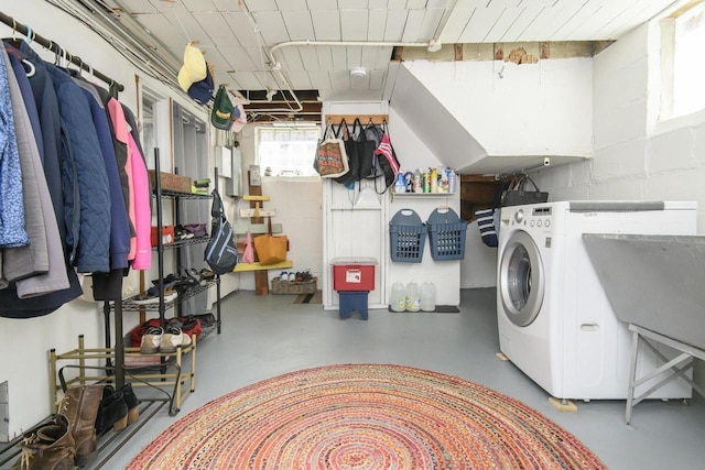 laundry area featuring laundry area, concrete block wall, washer / dryer, and a sink