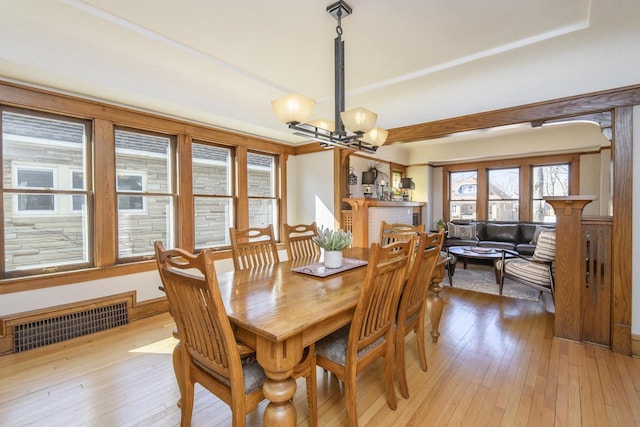 dining space featuring an inviting chandelier, light wood-style flooring, and visible vents