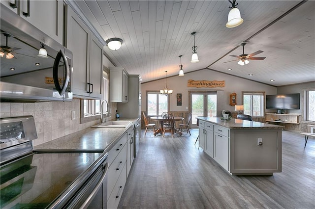 kitchen featuring stainless steel appliances, wood finished floors, a sink, and gray cabinetry