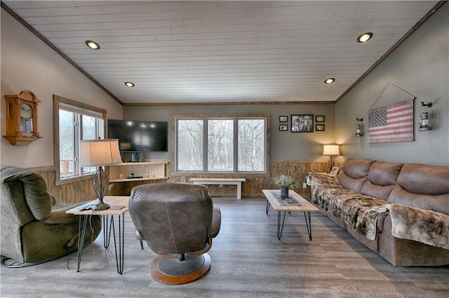 living room with wooden walls, wainscoting, wood finished floors, and crown molding