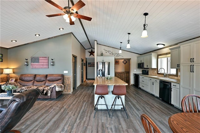 kitchen featuring crown molding, open floor plan, a sink, black appliances, and a kitchen breakfast bar