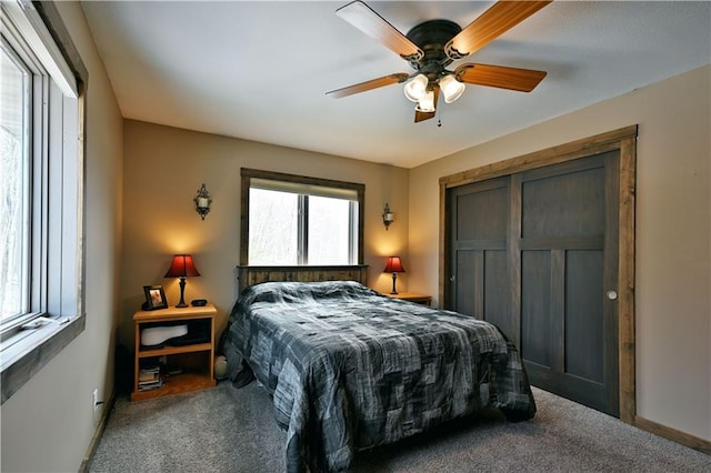 carpeted bedroom with ceiling fan and a closet