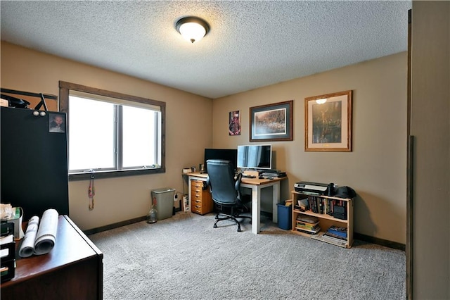 carpeted office space with a textured ceiling and baseboards