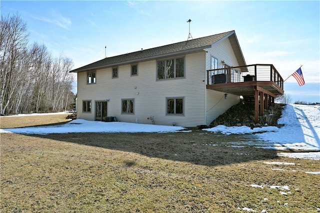 snow covered back of property featuring a wooden deck