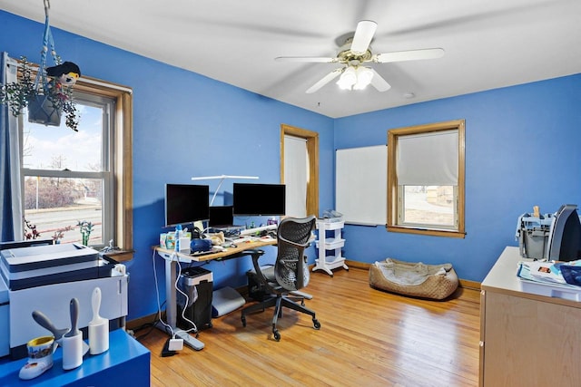 office space featuring light wood-style floors, ceiling fan, and baseboards