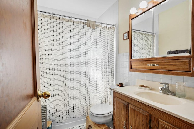 bathroom with toilet, a shower with shower curtain, vanity, and tile walls