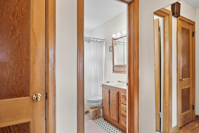 bathroom featuring toilet, a shower with curtain, and vanity