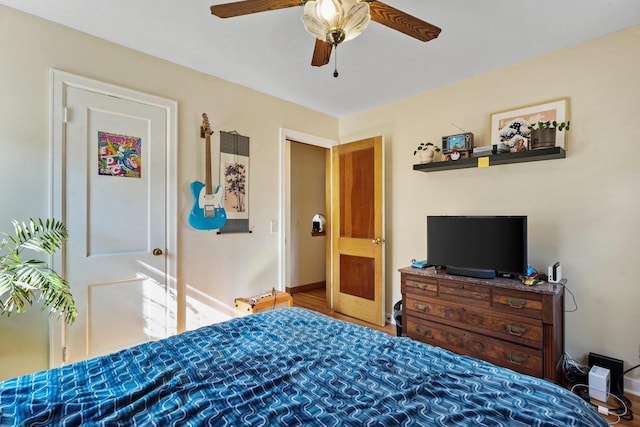 bedroom with a ceiling fan, baseboards, and wood finished floors