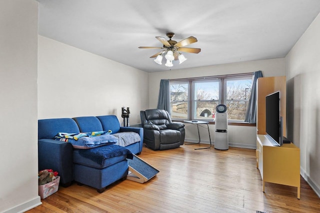 sitting room featuring ceiling fan, baseboards, and wood finished floors