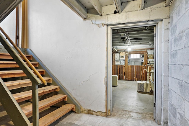 staircase featuring concrete floors and concrete block wall