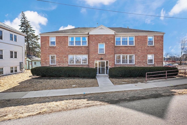 view of front of property featuring fence and brick siding