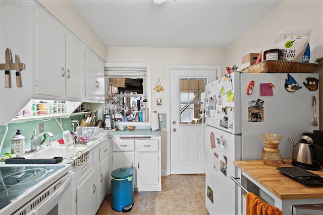 kitchen featuring white appliances, light tile patterned floors, white cabinetry, and light countertops