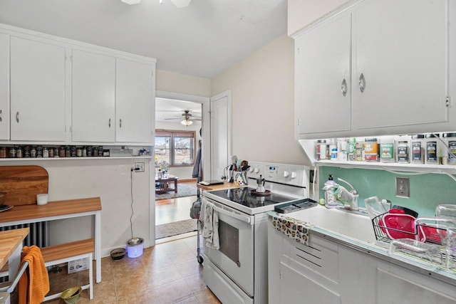 kitchen with electric range, white cabinetry, ceiling fan, and light countertops