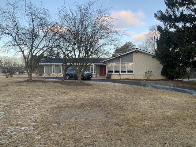 view of front of home with brick siding and a front yard