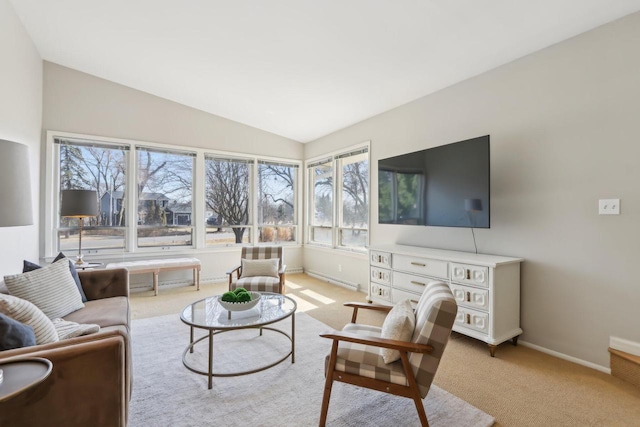 living room with baseboards, lofted ceiling, and light carpet