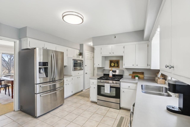 kitchen featuring light tile patterned floors, white cabinets, stainless steel appliances, and light countertops