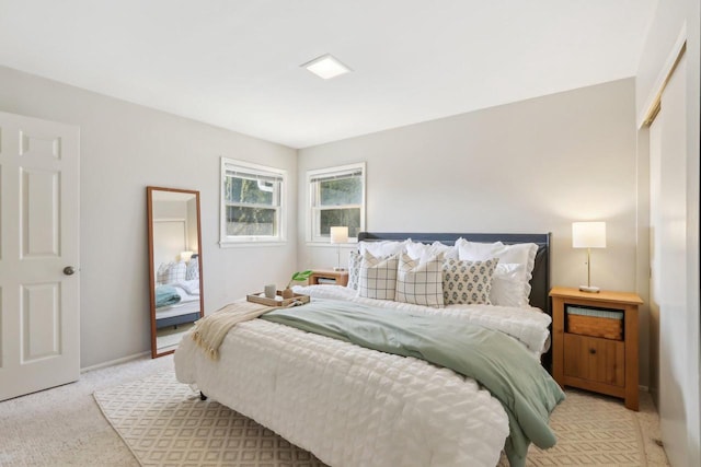 bedroom featuring light colored carpet and baseboards