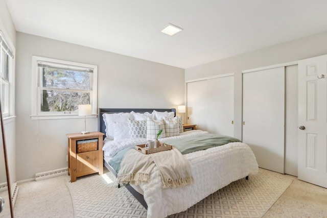 bedroom with baseboard heating and two closets