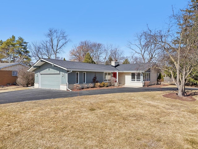 ranch-style house featuring driveway, an attached garage, a chimney, a front lawn, and board and batten siding