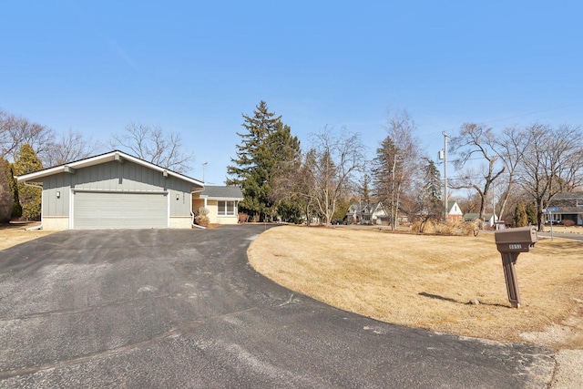 view of front of property featuring a garage, a front yard, and driveway