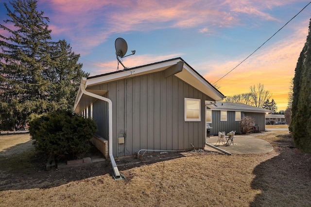 property exterior at dusk featuring a patio