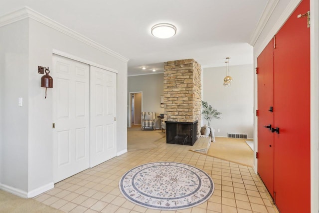 foyer featuring visible vents, baseboards, light tile patterned flooring, a fireplace, and crown molding