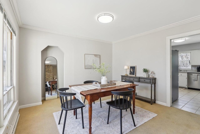 dining area featuring arched walkways, light colored carpet, baseboards, and ornamental molding