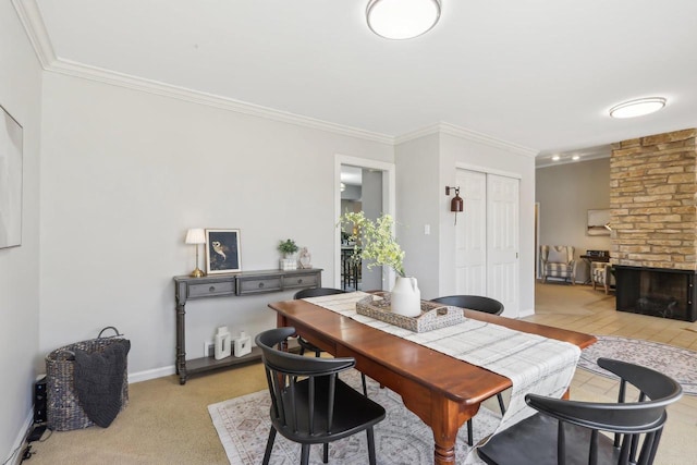 dining area with baseboards, light carpet, a fireplace, and crown molding