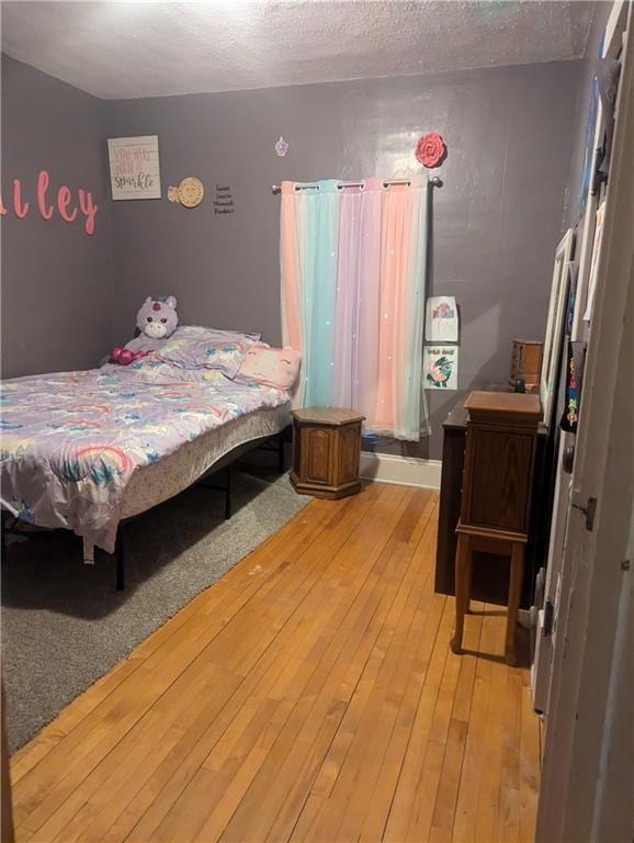 bedroom with light wood-type flooring and a textured ceiling