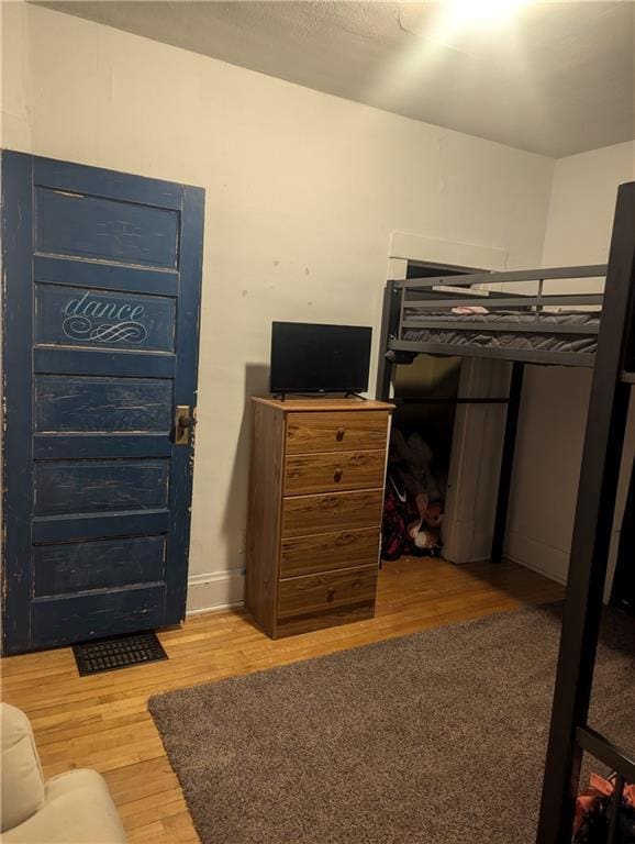 bedroom featuring baseboards and wood finished floors