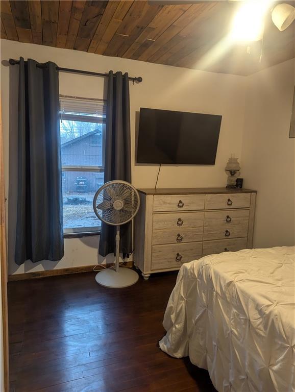 bedroom featuring wooden ceiling and dark wood-type flooring