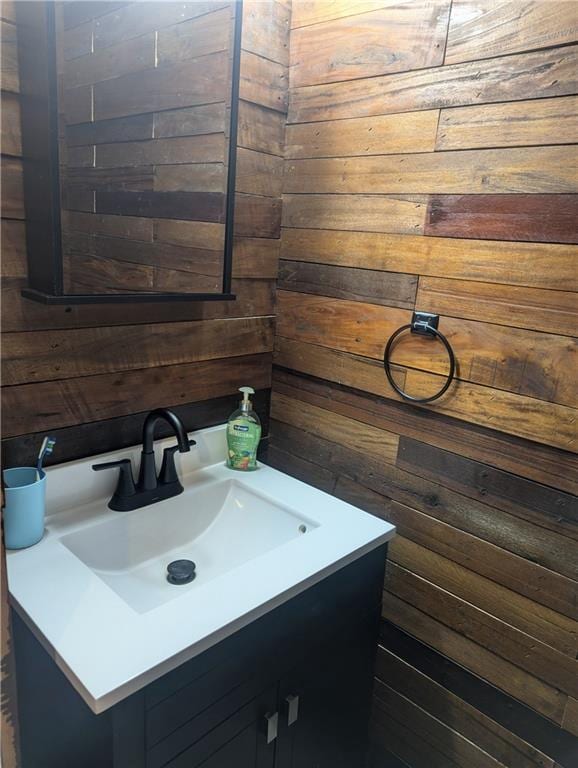 bathroom with wood walls and vanity