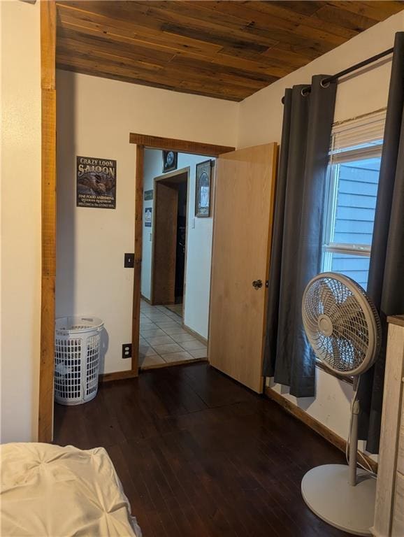 bedroom with wooden ceiling, baseboards, and wood finished floors