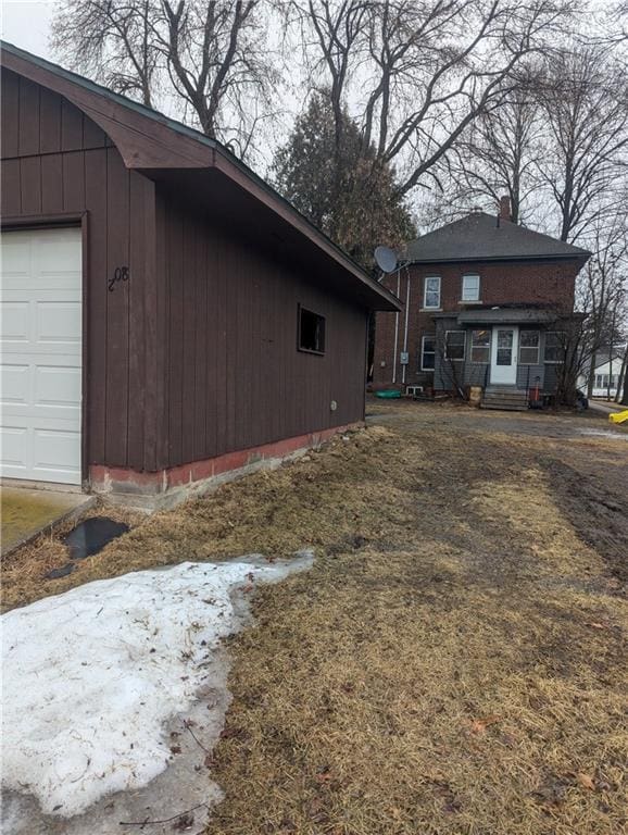 view of side of property featuring a garage and a chimney