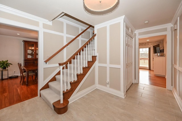 staircase featuring crown molding and wood finished floors