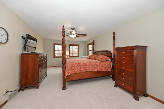 bedroom with light carpet, ceiling fan, and baseboards