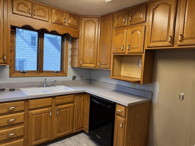 kitchen with dishwasher, brown cabinetry, and a sink