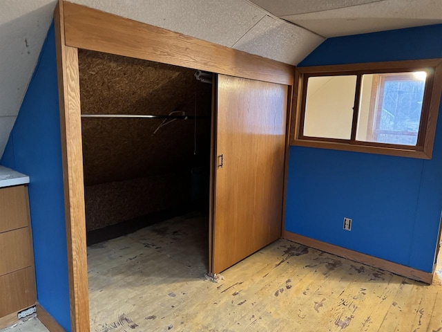 unfurnished bedroom with a closet and vaulted ceiling