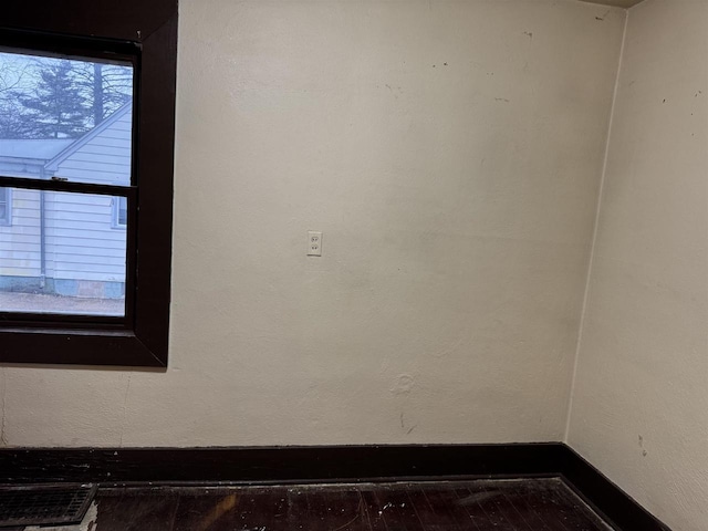 interior space with baseboards, wood finished floors, and a textured wall