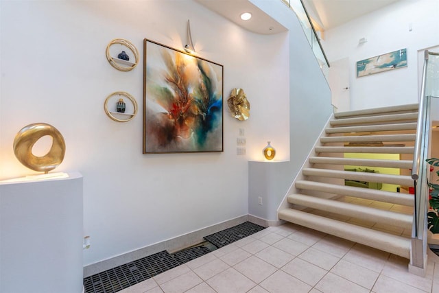 staircase with tile patterned flooring and baseboards