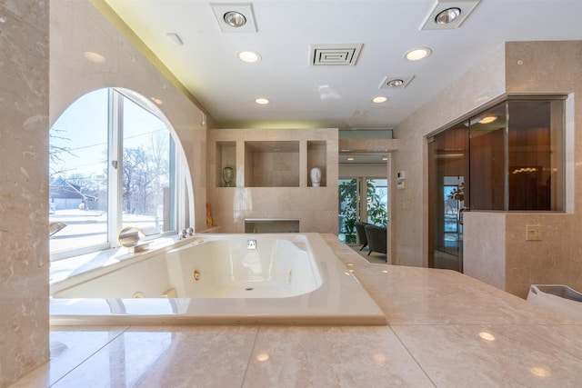 full bath featuring visible vents and a jetted tub