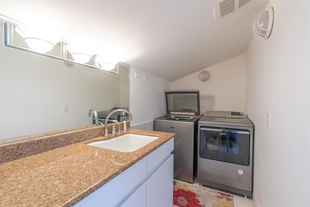 washroom featuring laundry area, light tile patterned floors, visible vents, washer and dryer, and a sink