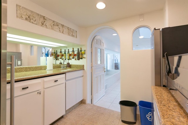 kitchen featuring visible vents, white cabinets, light tile patterned flooring, a sink, and recessed lighting