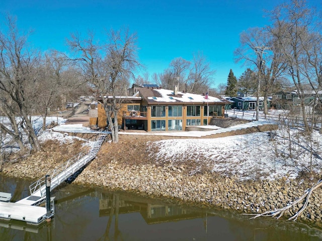 snow covered property with a water view