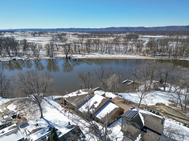 snowy aerial view featuring a water and mountain view